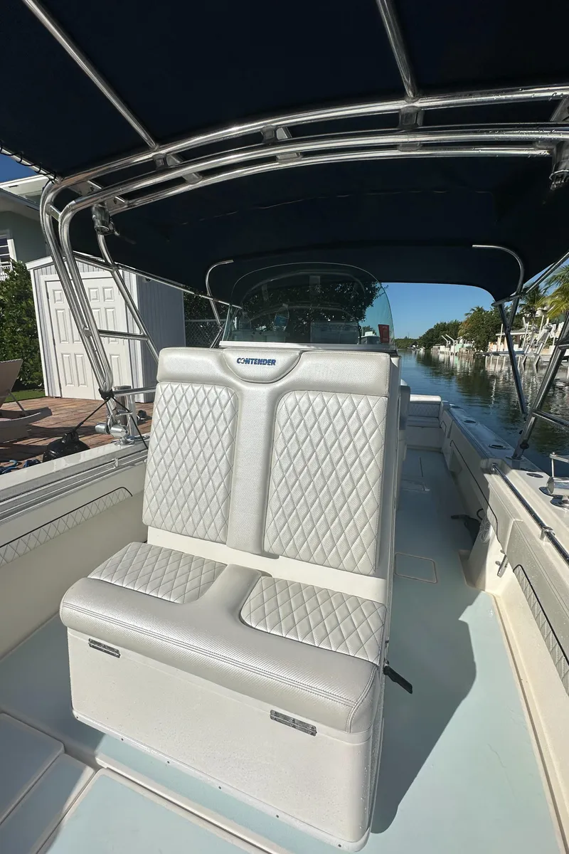 Slide: The Image of 2012 Contender 32 LS boat with cushioned seating and canopy. - 27