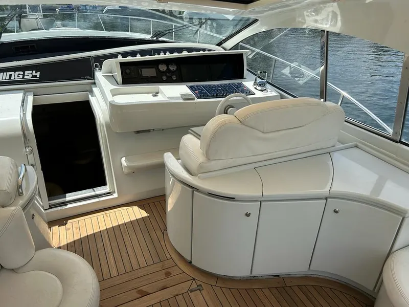 Slide: The Image of 1999 Pershing 54 yacht interior with white leather seating and wooden flooring. - 12