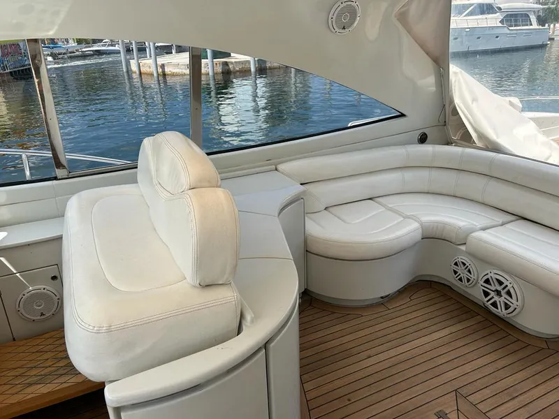 Slide: The Image of Interior of a 1999 Pershing 54 yacht with white leather seating and wooden flooring. - 13