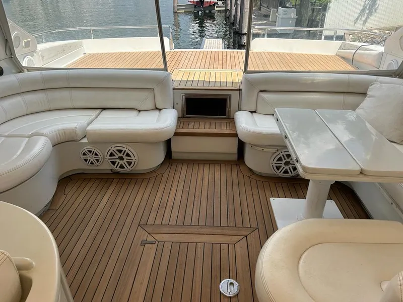 Slide: The Image of Luxurious 1999 Pershing 54 yacht interior with white leather seating and teak flooring. - 14