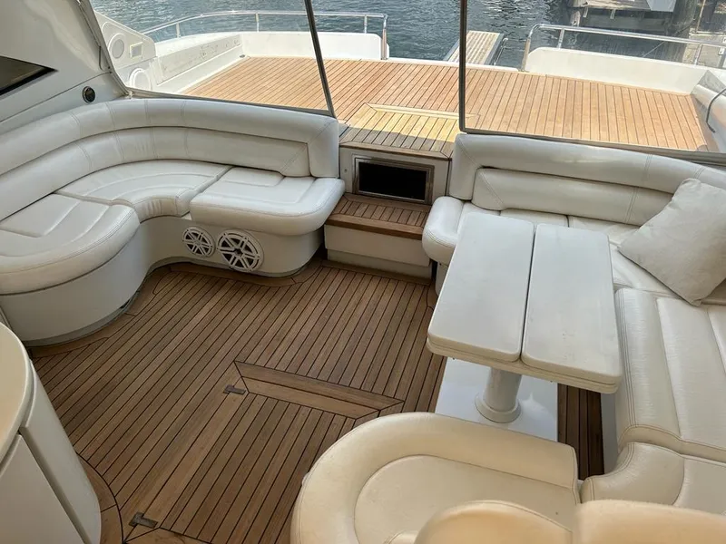 Slide: The Image of Luxurious 1999 Pershing 54 yacht interior with white leather seating and wooden flooring. - 15