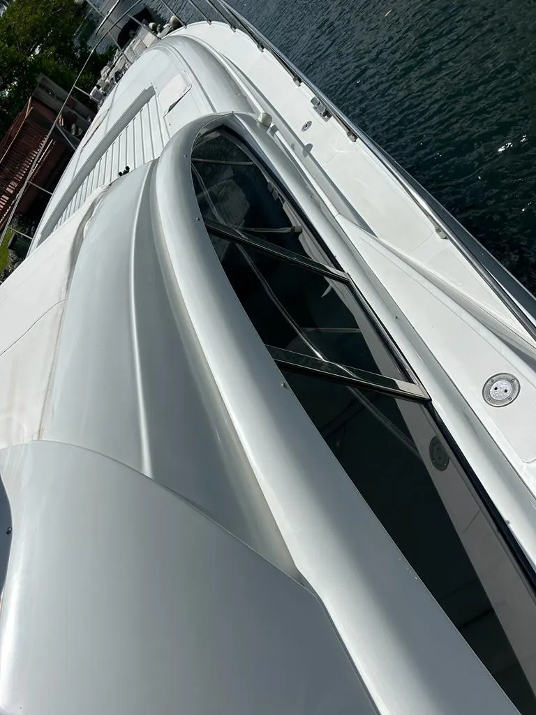 Slide: The Image of 1999 Pershing 54 yacht, sleek white exterior, docked by the water. - 17