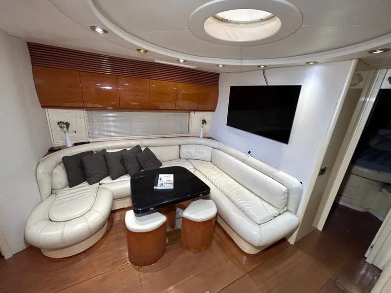 Slide: The Image of Luxurious interior of a 1999 Pershing 54 yacht with white leather seating and a flat-screen TV. - 19