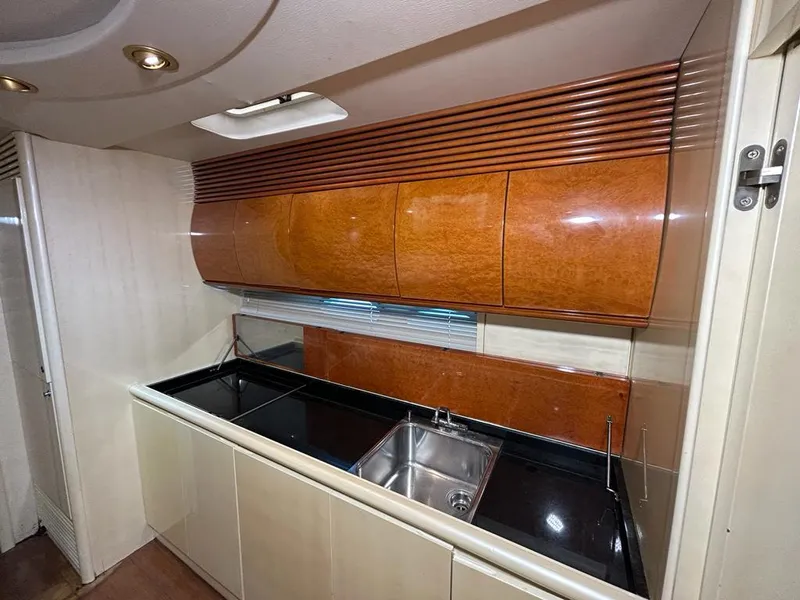 Slide: The Image of 1999 Pershing 54 yacht kitchen with sleek cabinetry and modern sink. - 20