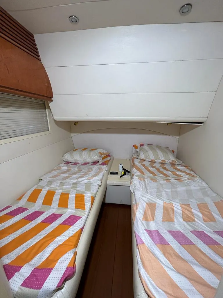 Slide: The Image of Twin bed cabin in 1999 Pershing 54 yacht with striped bedding. - 26