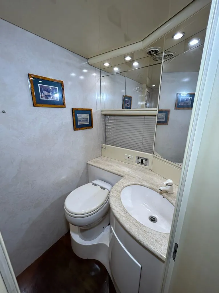 Slide: The Image of 1999 Pershing 54 yacht bathroom with modern fixtures and framed artwork. - 27
