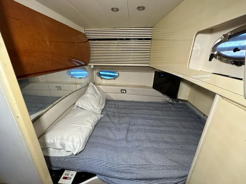 Slide: The Image of 1999 Pershing 54 yacht interior cabin with bed and porthole windows. - 33