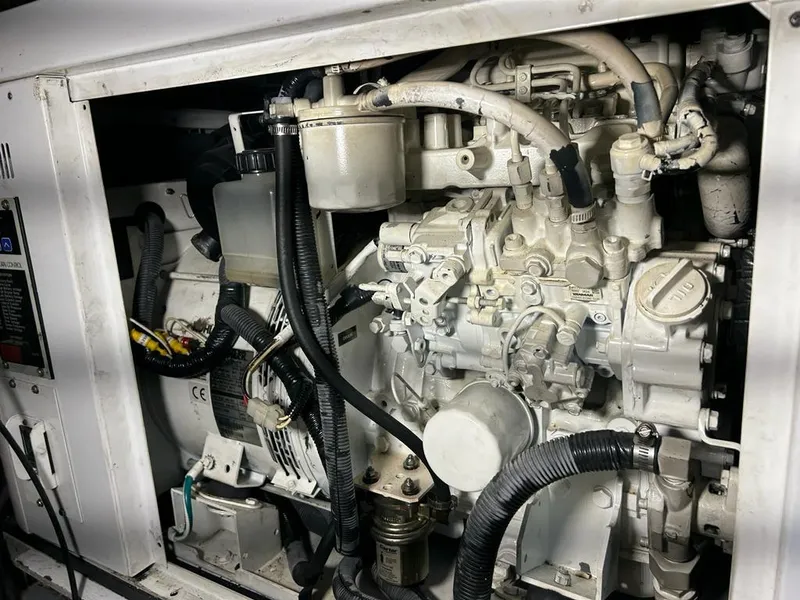Slide: The Image of Engine compartment of a 1999 Pershing 54 yacht, showcasing mechanical components and wiring. - 34