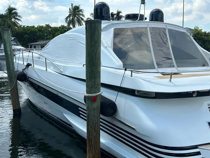 Slide: The Image of 1999 Pershing 54 yacht docked at marina with palm trees in background. - 40