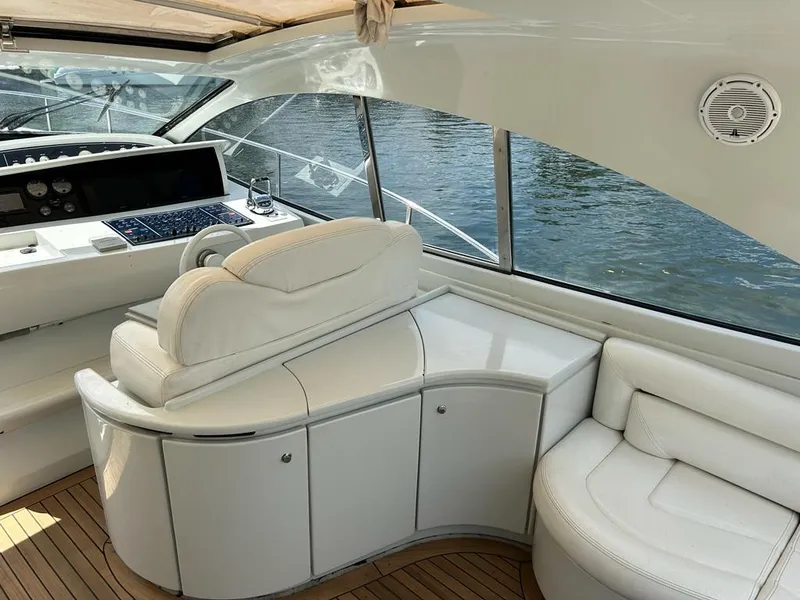 Slide: The Image of Interior of a 1999 Pershing 54 yacht with white leather seating and control panel. - 9