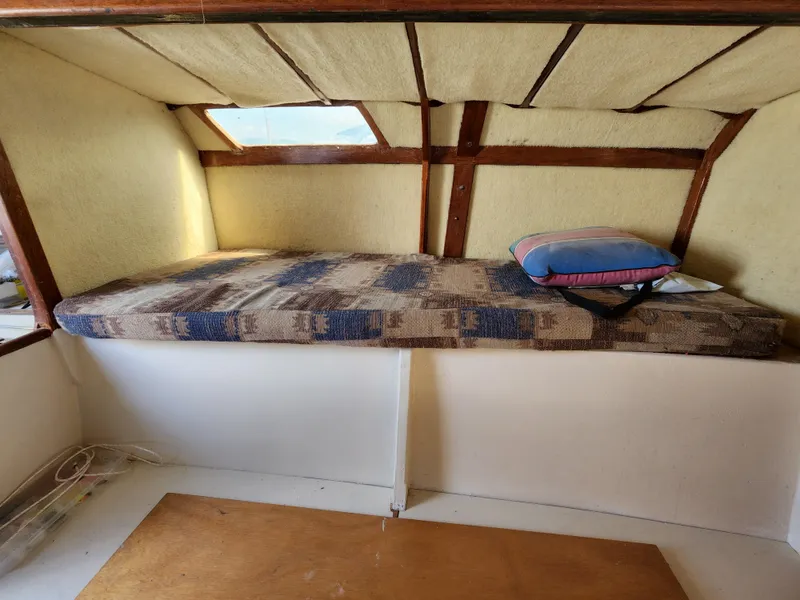 Slide: The Image of 1985 Crowther Buccaneer interior cabin with bed, wooden accents, and a small window. - 15