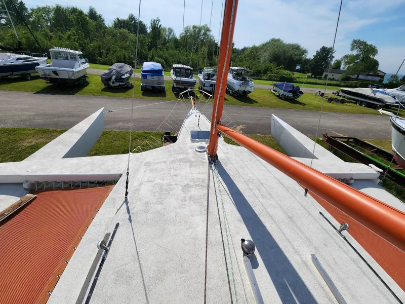 Slide: The Image of 1985 Crowther Buccaneer sailboat on land, surrounded by parked boats and greenery. - 3