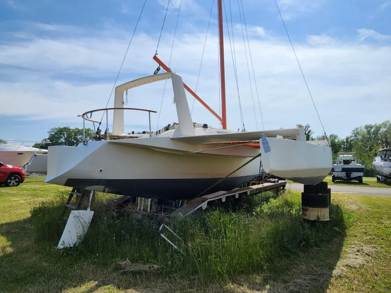 Slide: The Image of 1985 Crowther Buccaneer sailboat on land, grassy area, clear sky background. - 4