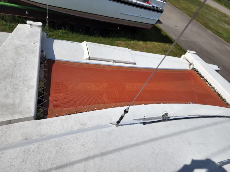 Slide: The Image of 1985 Crowther Buccaneer catamaran with orange netting on deck, docked on grass. - 8