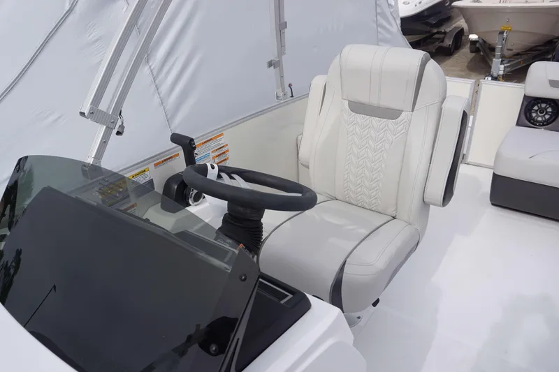 Slide: The Image of Captain's seat and helm of 2024 Hurricane FD 2360 RE3 boat with steering wheel and controls. - 12