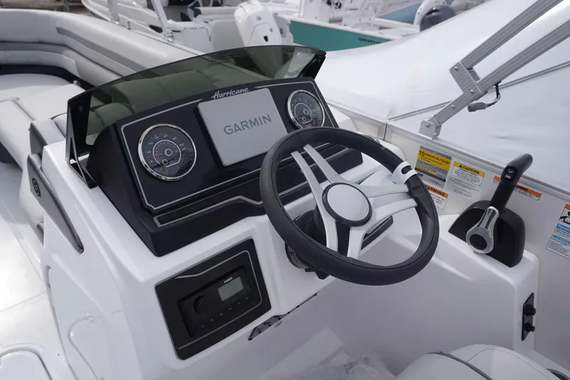 Slide: The Image of 2024 Hurricane FD 2360 RE3 boat dashboard with Garmin navigation system and steering wheel. - 3