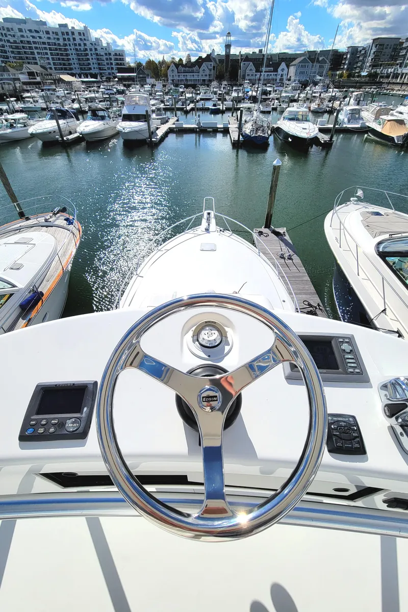 Slide: The Image of 2016 Viking 42 Sport Tower yacht helm overlooking marina. - 20