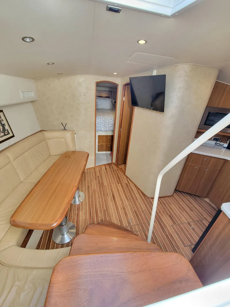 Slide: The Image of Interior of 2016 Viking 42 Sport Tower yacht with modern seating and wood flooring. - 24