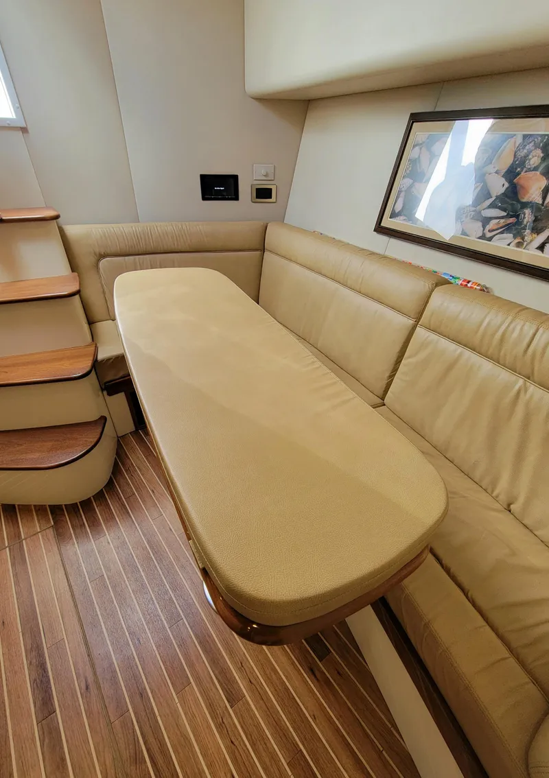 Slide: The Image of 2016 Viking 42 Sport Tower interior with beige seating and wooden flooring. - 26