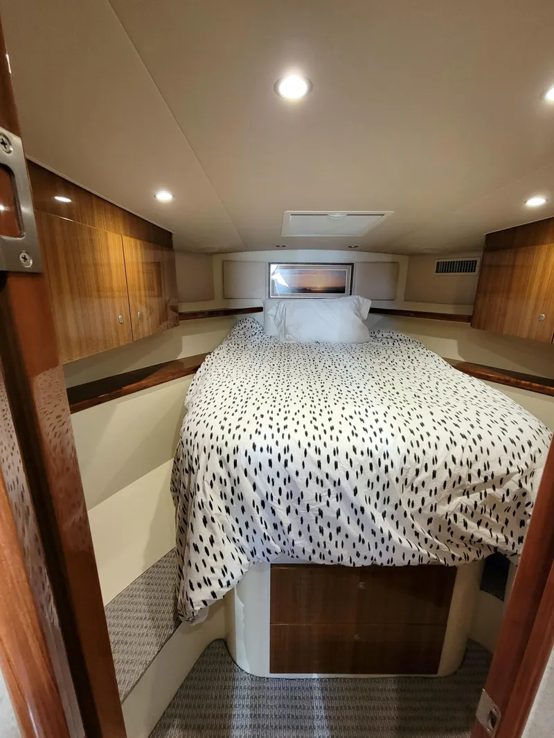 Slide: The Image of 2016 Viking 42 Sport Tower cabin with cozy bed and wooden accents. - 29