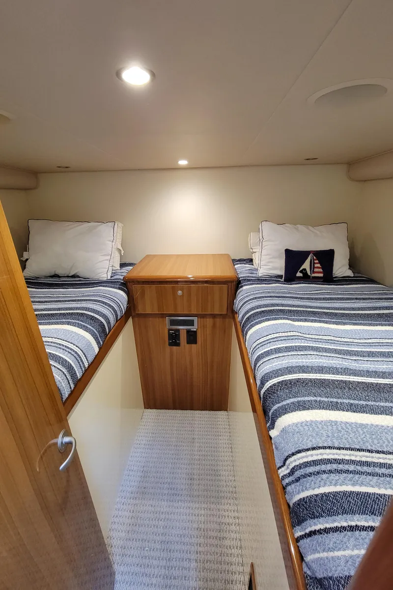 Slide: The Image of 2016 Viking 42 Sport Tower cabin with twin beds and striped bedding. - 30