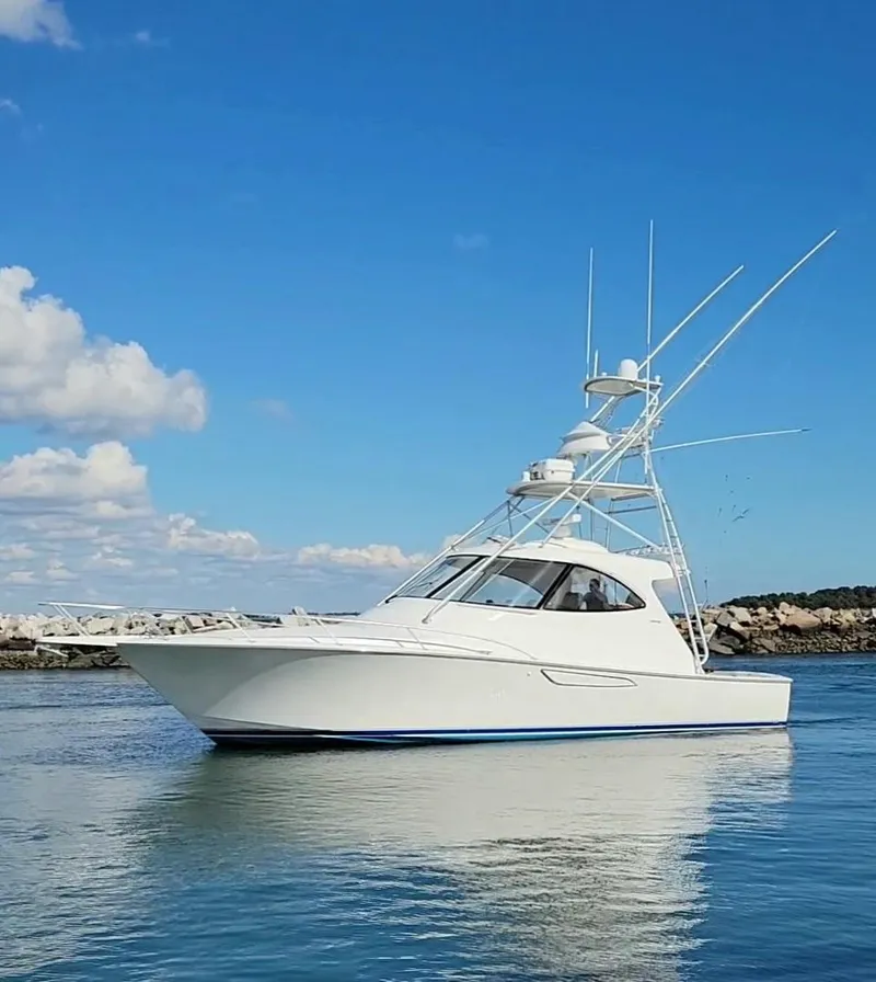 Slide: The Image of 2016 Viking 42 Sport Tower yacht on calm water under blue sky. - 35