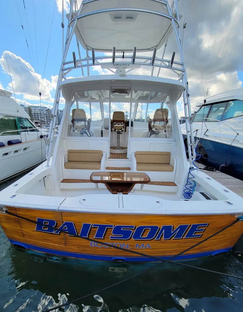 Slide: The Image of 2016 Viking 42 Sport Tower boat docked, featuring spacious seating and fishing equipment. - 4