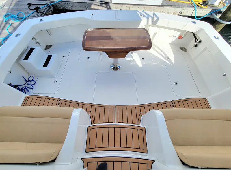 Slide: The Image of 2016 Viking 42 Sport Tower boat deck with teak flooring and central table. - 6
