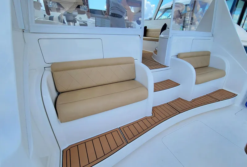 Slide: The Image of 2016 Viking 42 Sport Tower interior with tan seating and teak flooring. - 8