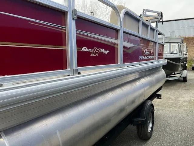 Slide: The Image of 2024 Sun Tracker Bass Buggy 18 DLX pontoon boat with red exterior. - 3