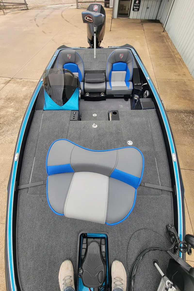 Slide: The Image of 2024 Triton 19 TrX fishing boat with blue and gray seating. - 3