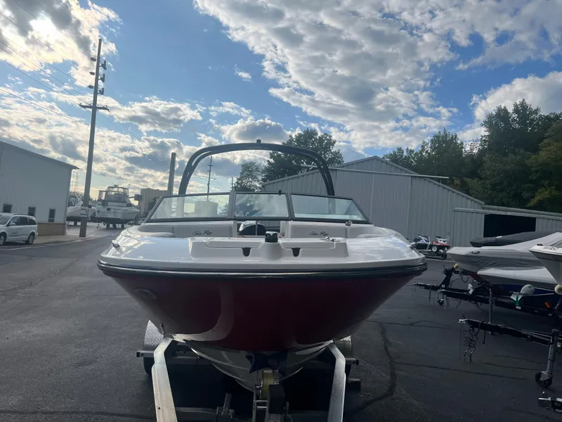 Slide: The Image of 2021 Sea Ray SPO 230 boat on trailer, parked outdoors under a partly cloudy sky. - 12