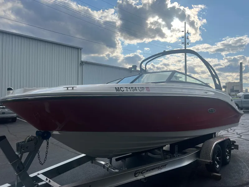 Slide: The Image of 2021 Sea Ray SPO 230 boat on trailer, red and white, parked outdoors. - 13