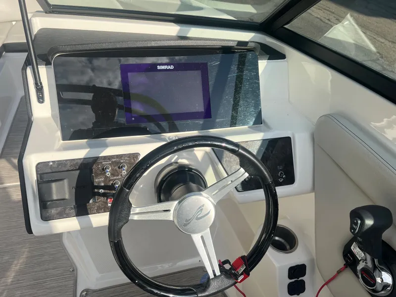 Slide: The Image of 2021 Sea Ray SPO 230 boat dashboard with steering wheel and navigation system. - 9