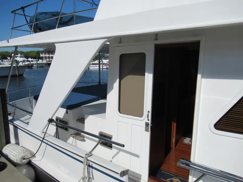 Slide: The Image of 2010 DeFever 48 Offshore yacht docked, showing side entrance and deck area. - 10