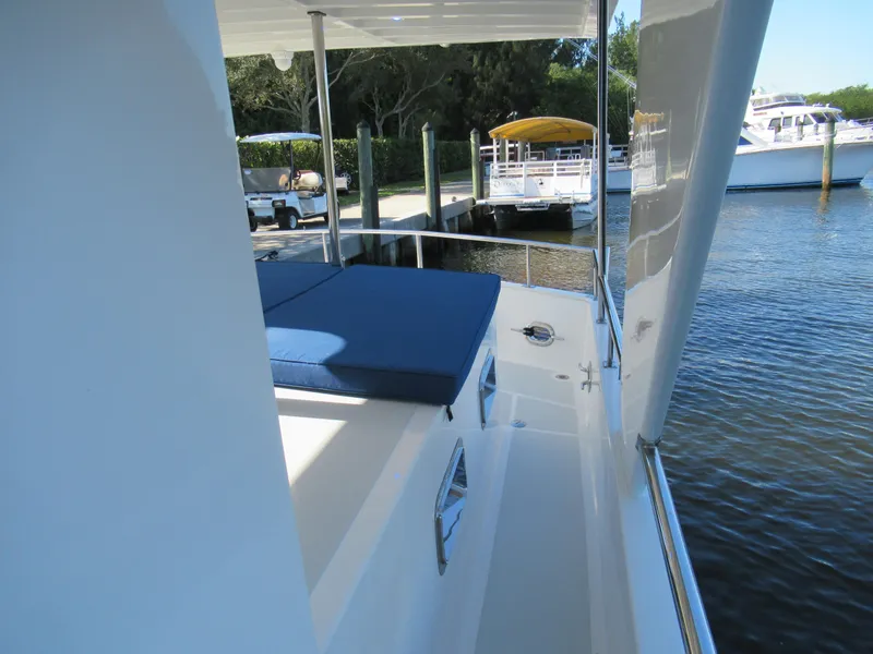 Slide: The Image of 2010 DeFever 48 Offshore yacht deck with blue cushions, docked at marina. - 20