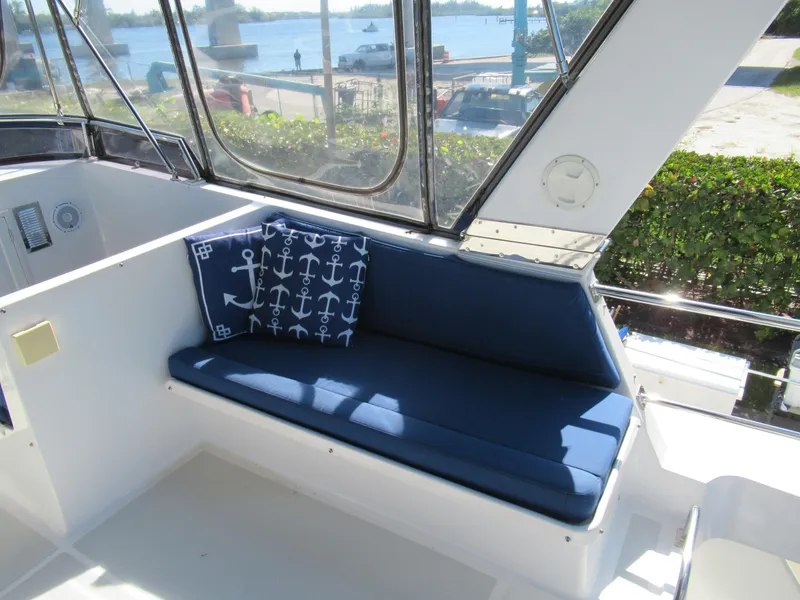 Slide: The Image of DeFever 48 Offshore 2010 boat interior with blue cushioned seating and anchor-themed pillows. - 29