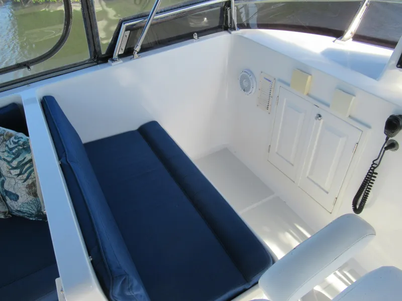 Slide: The Image of DeFever 48 Offshore 2010 boat interior with blue cushioned seating and white cabinetry. - 32