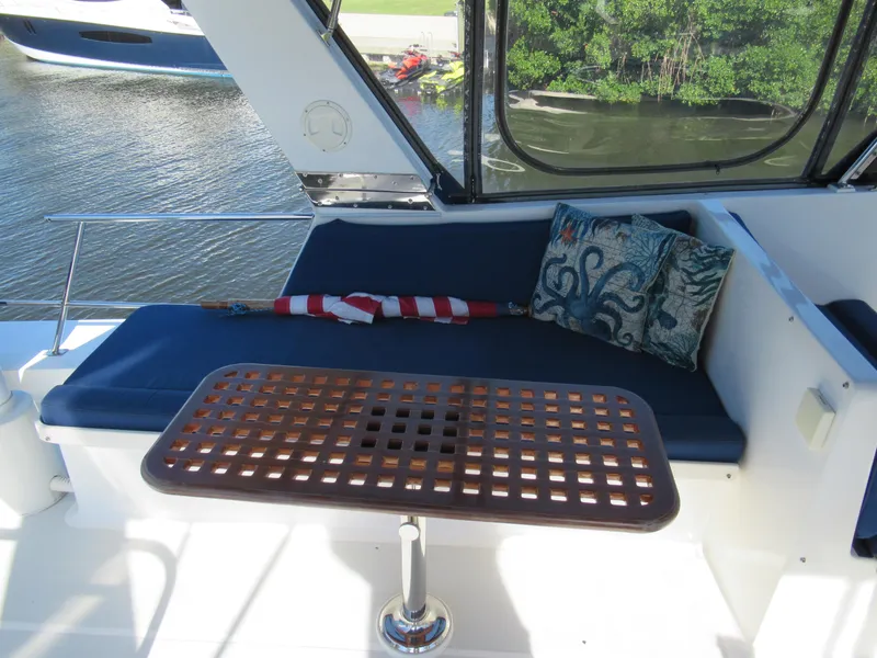 Slide: The Image of DeFever 48 Offshore 2010 yacht interior with cushioned seating and wooden table. - 33