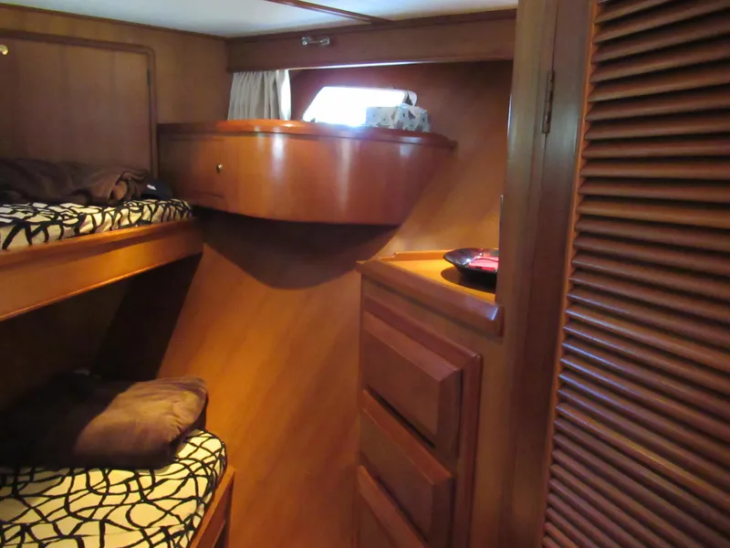 Slide: The Image of 2010 DeFever 48 Offshore cabin with wooden bunk beds and storage. - 44