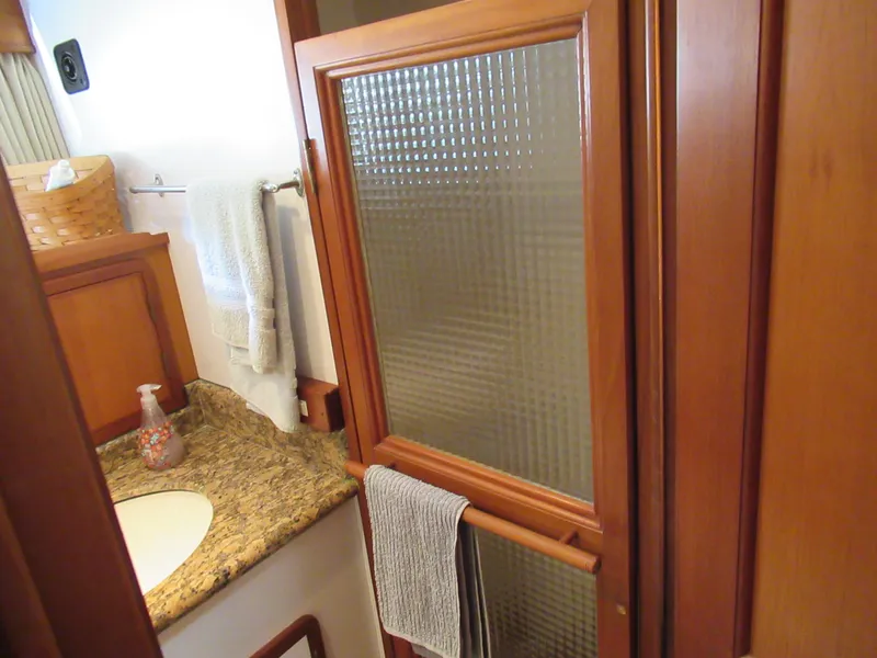 Slide: The Image of Bathroom interior of 2010 DeFever 48 Offshore yacht with granite countertop and wooden shower door. - 49