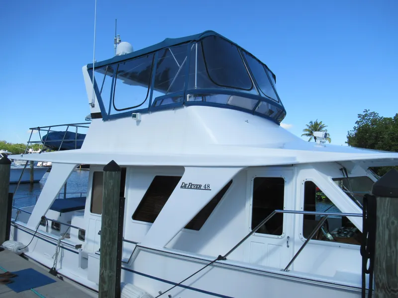 Slide: The Image of 2010 DeFever 48 Offshore yacht docked, side view with blue canopy. - 5