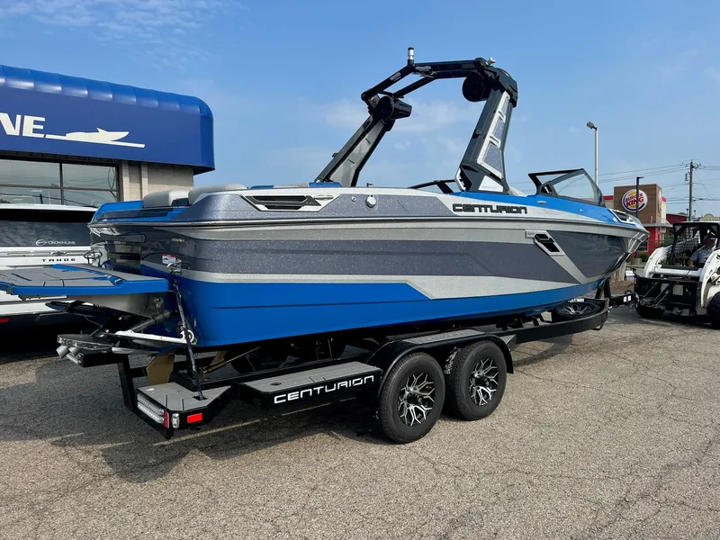 Slide: The Image of 2024 Centurion Ri245 boat on a trailer, blue and gray exterior. - 1