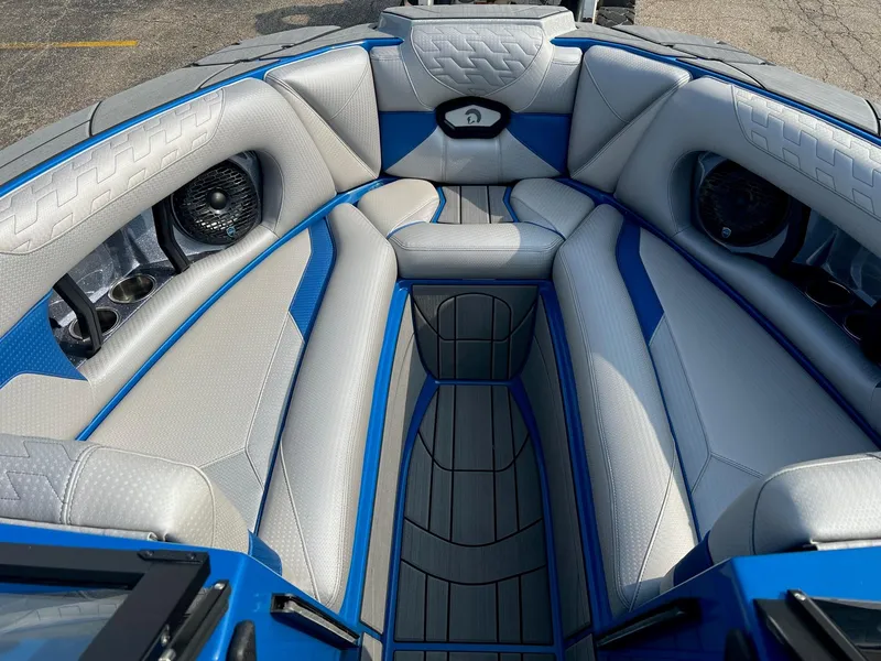 Slide: The Image of 2024 Centurion Ri245 boat interior with blue and gray seating and built-in speakers. - 3