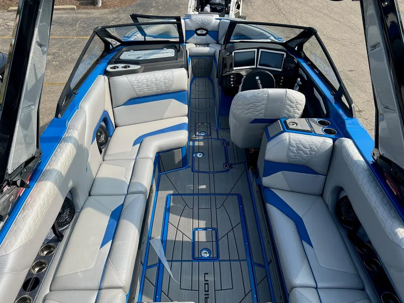 Slide: The Image of 2024 Centurion Ri245 boat interior with blue and white seating, modern dashboard, and spacious layout. - 4
