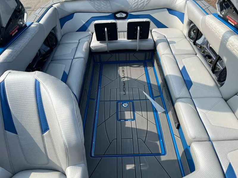Slide: The Image of 2024 Centurion Ri245 boat interior with white and blue seating and deck. - 6