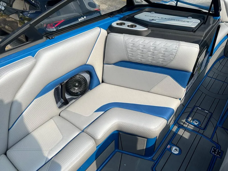 Slide: The Image of 2024 Centurion Ri245 boat interior with blue and white cushioned seating and built-in speaker. - 8