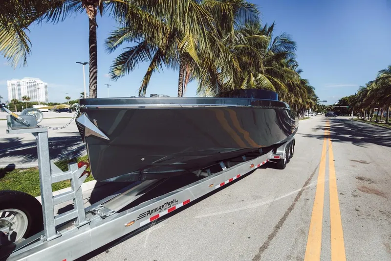 Slide: The Image of 2020 Frauscher 1017 GT boat on trailer, parked on a palm-lined street. - 18