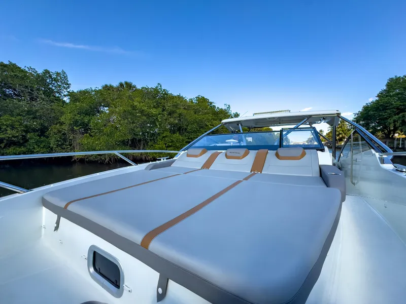 Slide: The Image of 2024 Beneteau Flyer 10 boat with sleek design and spacious deck, surrounded by lush greenery. - 20