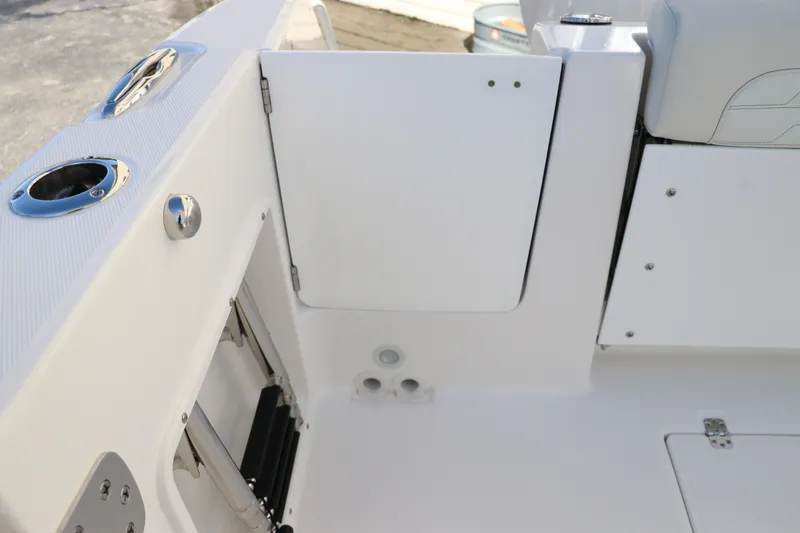 Slide: The Image of 2024 Edgewater 262CX boat interior, featuring a white access door and seating area. - 14